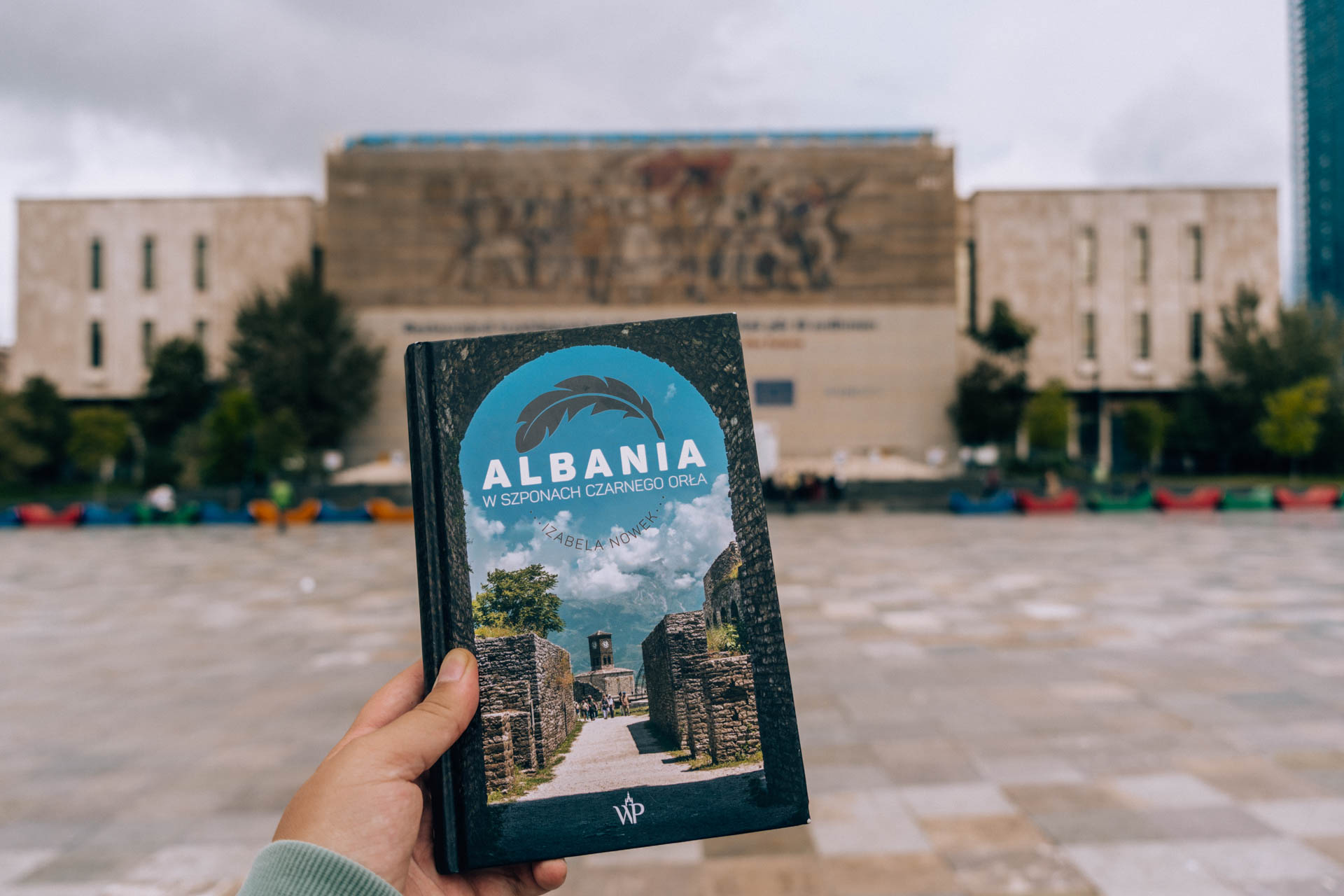 Książka o Albanii na tle Muzeum Historycznego w Tiranie